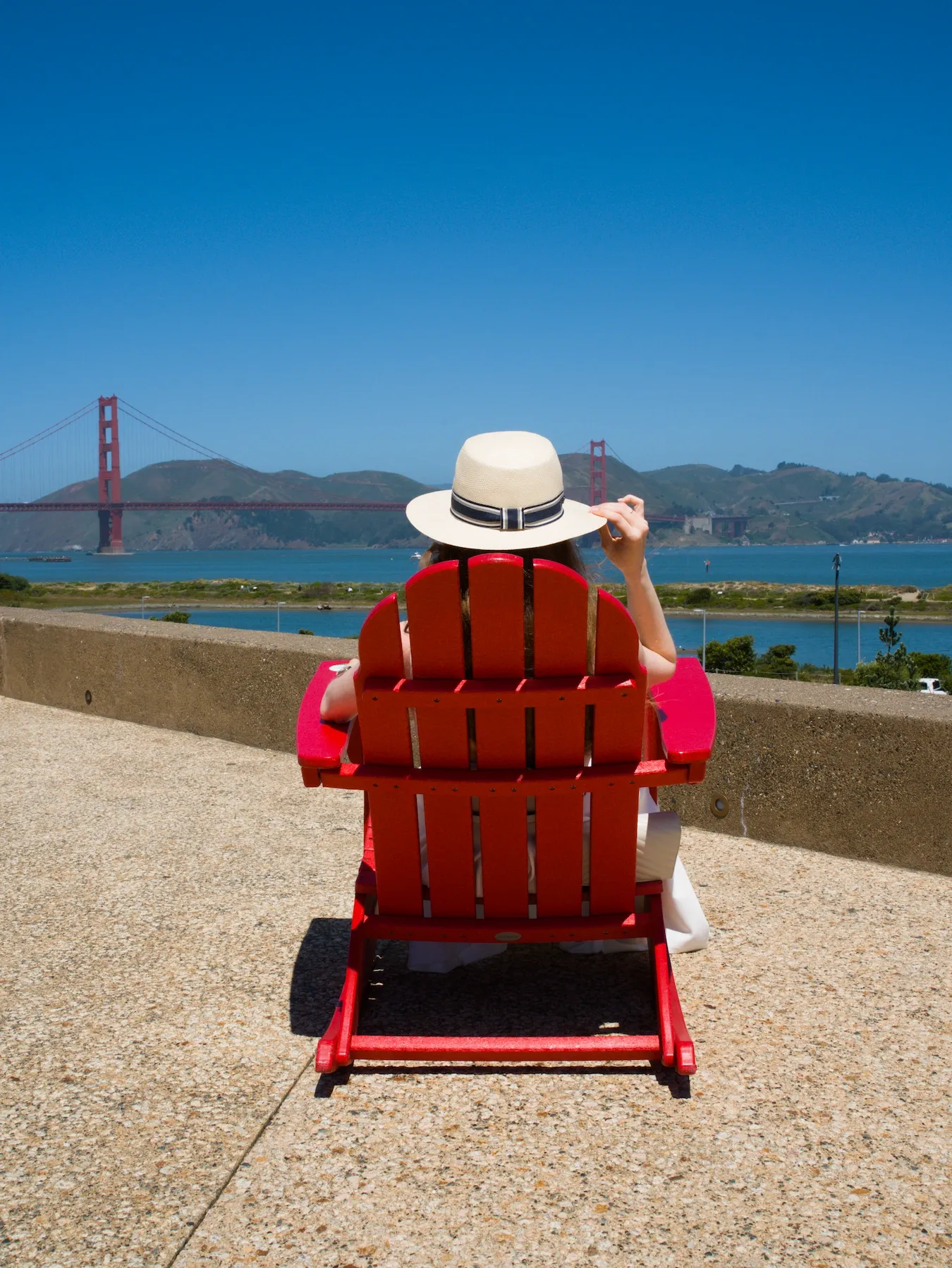 A person sitting in the red chair facing Golden Gate Bridge