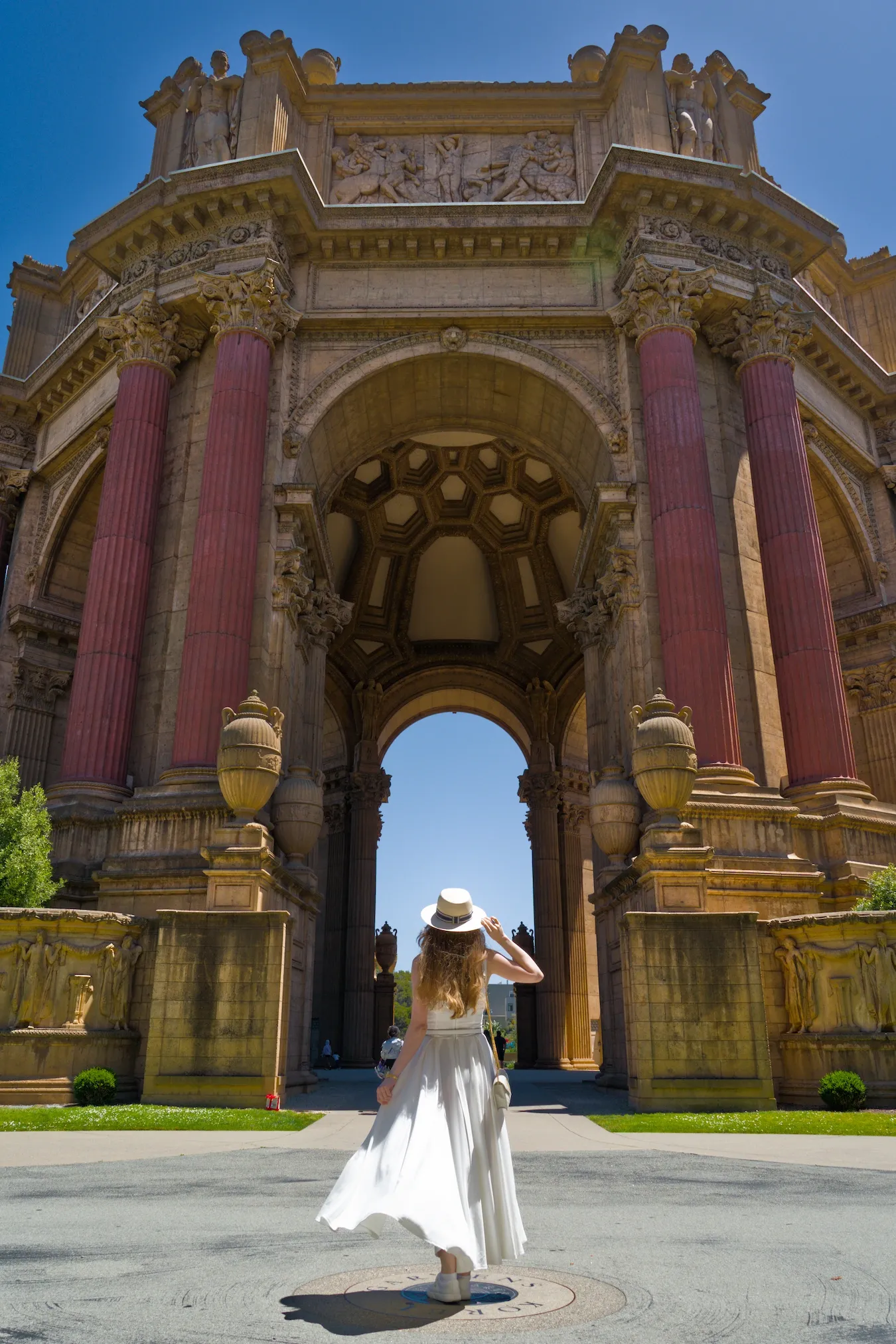 A woman in a white dress standing in from of Rotunda in Palace of Fine Arts, San Francisco